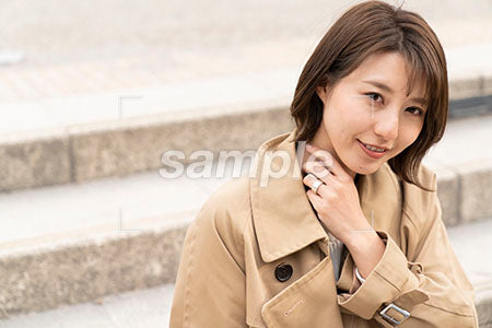 茶色のコートを着た女性が座って正面を見る a0050436PH
