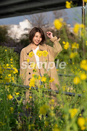 春の菜の花越しの女性 正面を見る a0050584PH