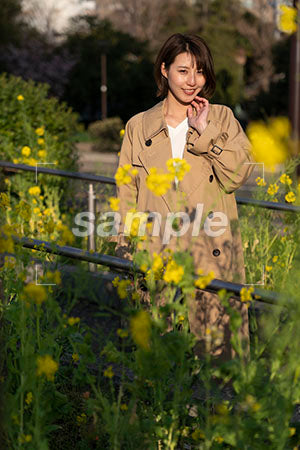 黄色い花越しの女性 正面を見る a0050600PH