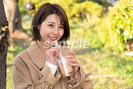 外でタピオカドリンクを飲むボブの髪型の女性 a0050676PH