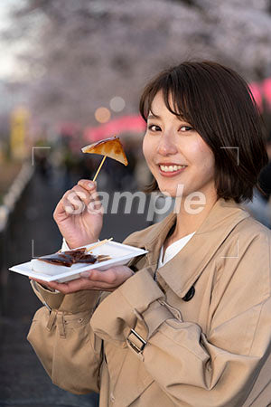 花見で食べ物を食べる女性 a0050717PH