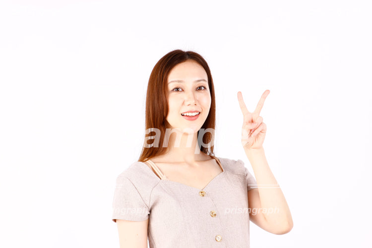茶色い髪の女性がVサインのジェスチャーをしている a0090204