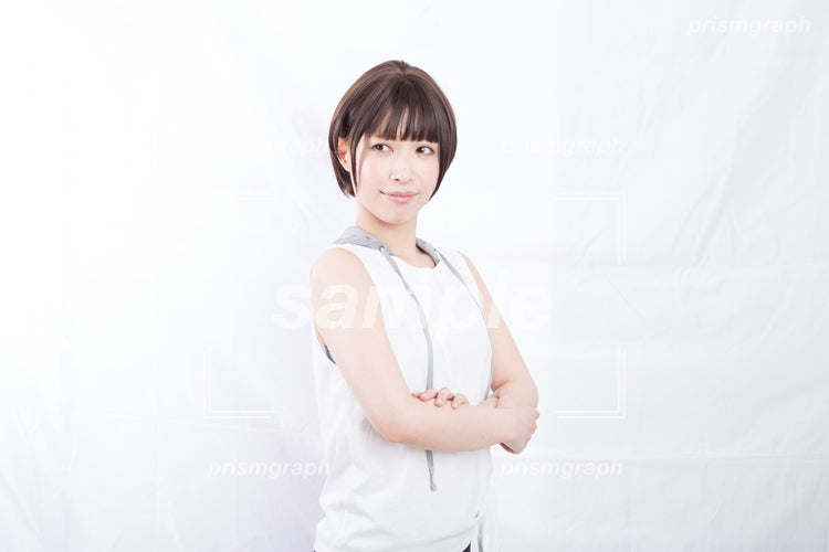 白いスポーツウェアを着て腕組みしている女子 ab0070075