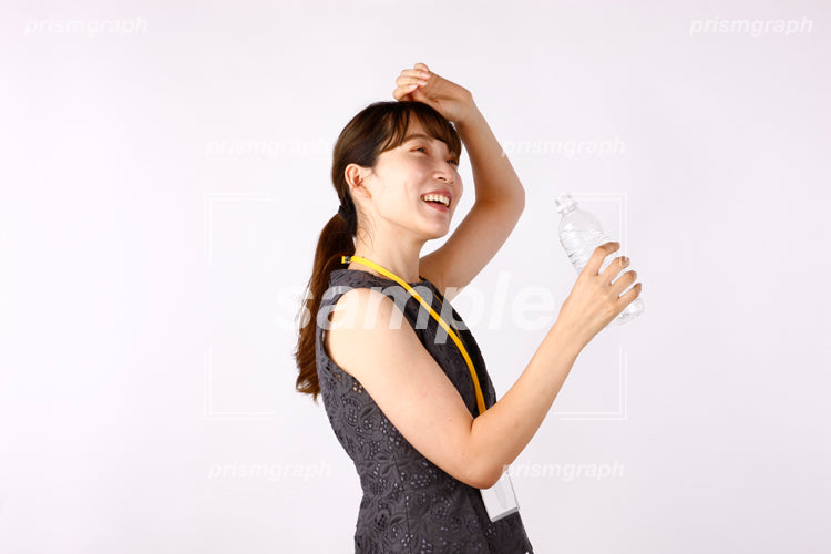 汗を拭いている女性がペットボトルを持っている af0080069