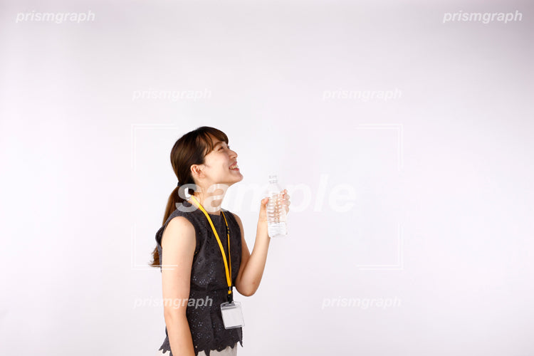 髪を結んだ女性が水を飲んで上を仰ぎ見る af0080072