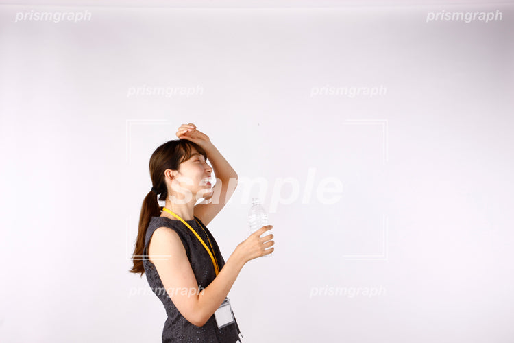 女性がPETボトルをもちながら汗を拭いている af0080078
