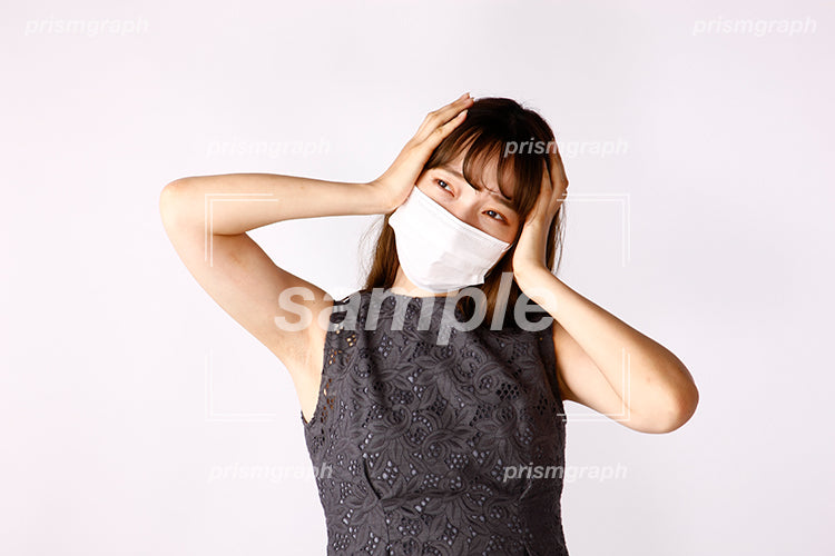 心配な表情で耳を塞いでいるマスクの女性 ak080038