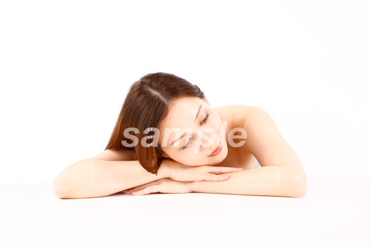 白いテーブルの上で寝ている女性 aq0090003
