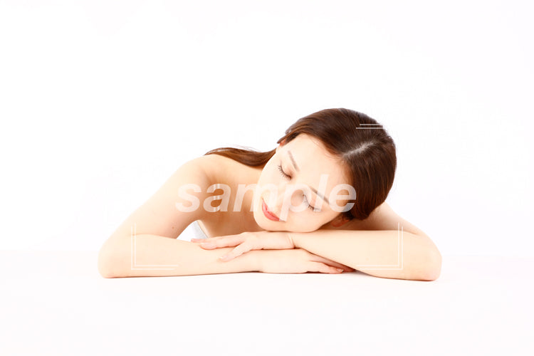 チューブトップの美人の女性がテーブルで寝ている aq0090011