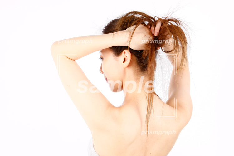 髪を巻こうとしている女性の仕草 aq0090035