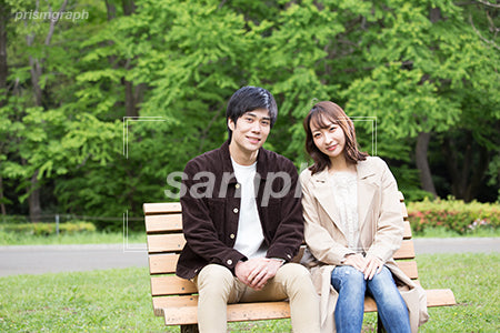 公園のベンチに腰掛けてデートしている ay0060084PH
