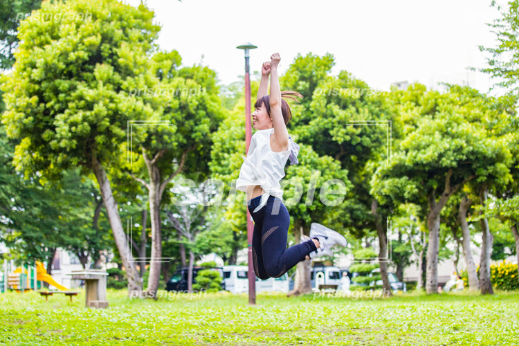 公園でジャンプしている女性 ay0070099